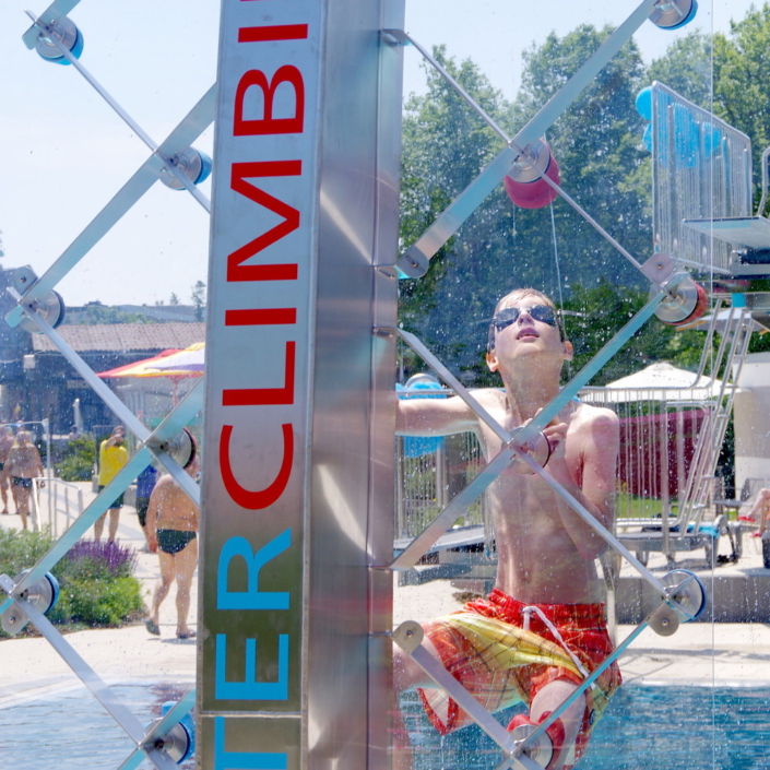 Transparente Kletterfläche einer WATERCLIMBING-Schwimmbadkletterwand